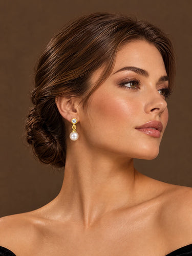 Model wearing yellow gold freshwater pearl drop earrings