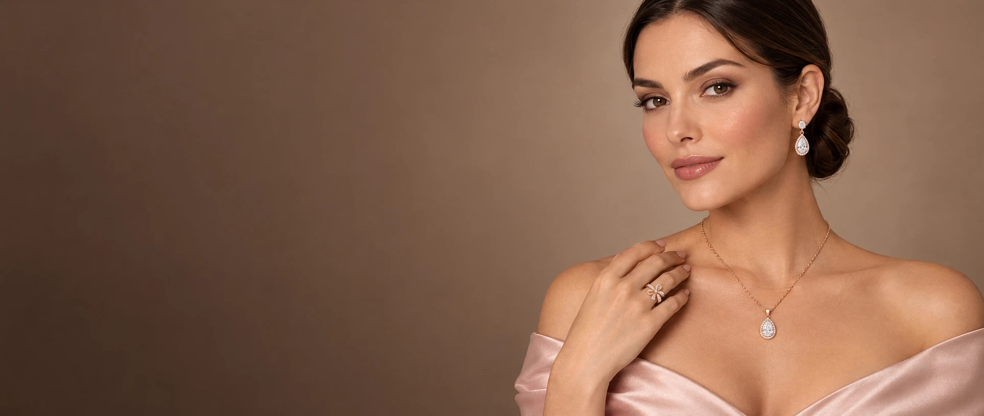 Model wearing rose gold pear halo necklace, earrings and bow ring