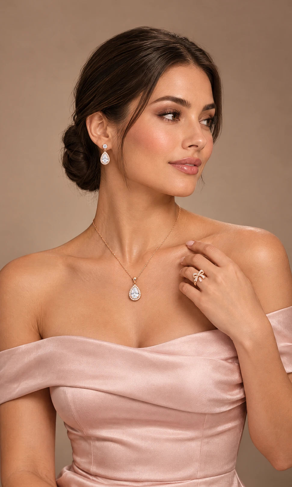 Model wearing rose gold pear halo necklace, earrings and bow ring
