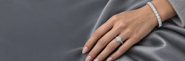 White gold halo solitaire ring and emerald cut tennis bracelet on hand