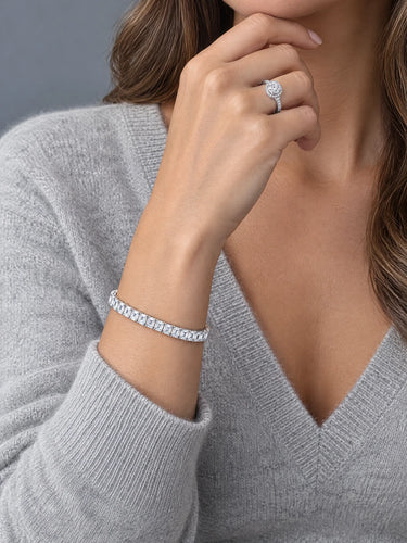 White gold halo solitaire ring and emerald cut tennis bracelet on hand